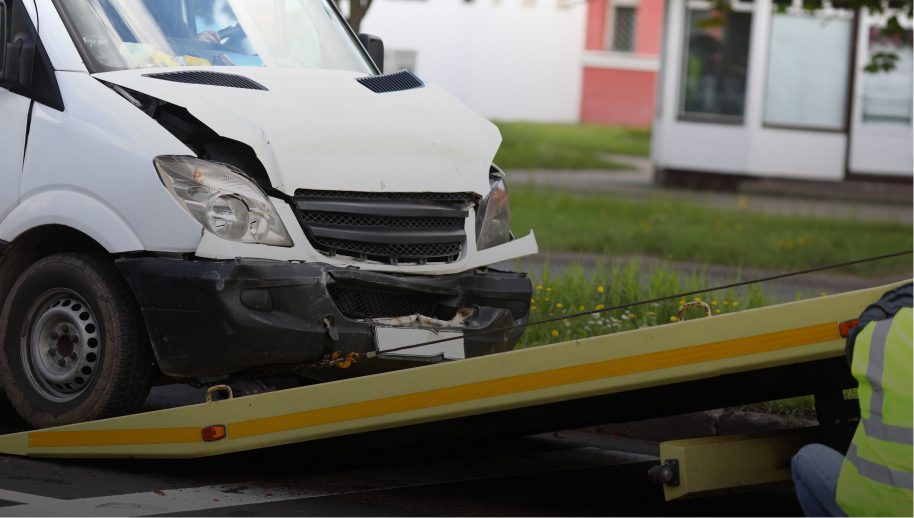 Damaged van being loaded onto tow truck.